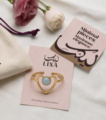 A delicate heart design highlighted by a striking blue stone.