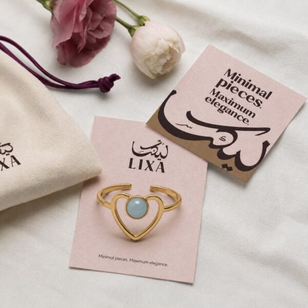A delicate heart design highlighted by a striking blue stone.